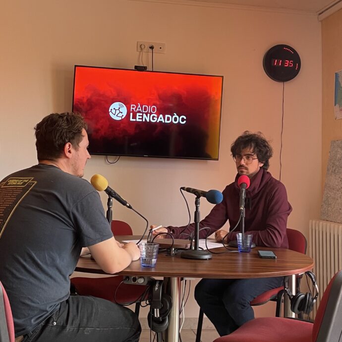 Liam Hainaut et Julien Delrieu en studio, échangeant sur des sujets captivants, avec des éléments visuels représentant la créativité et la collaboration.